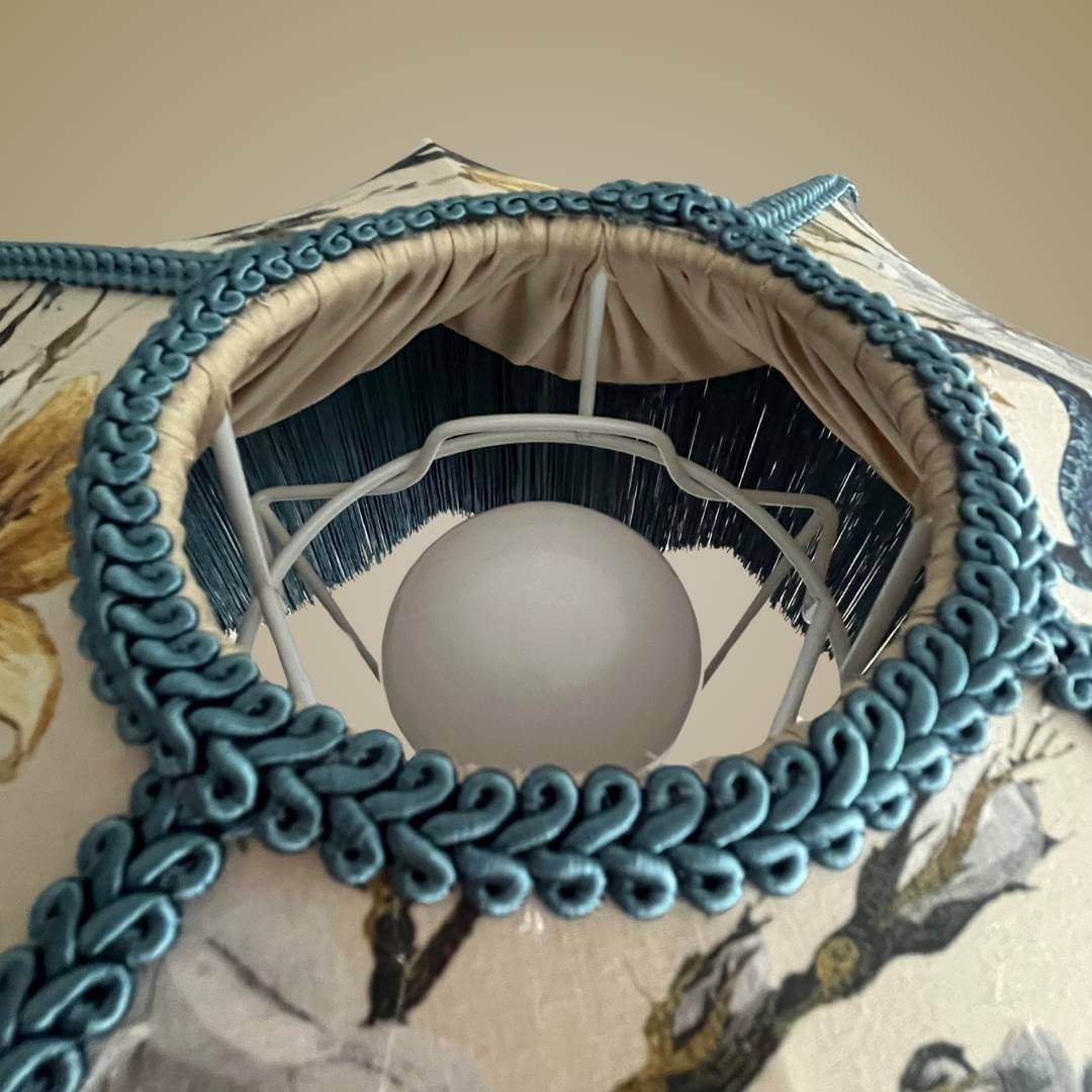Art Deco style lampshade with pretty florals entertwined with snakes and a long blue fringe showing detail of top