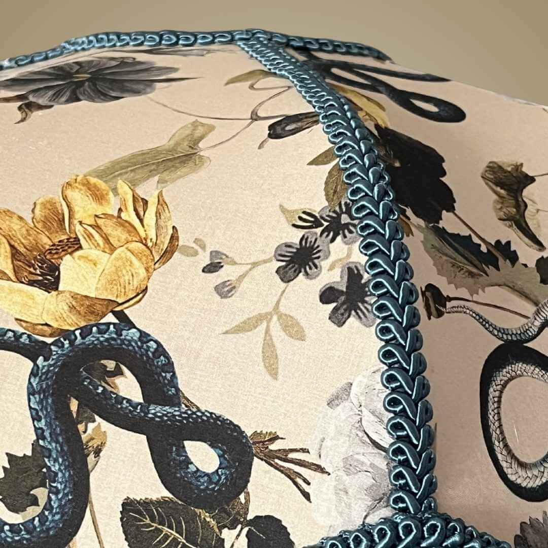 Art Deco style lampshade with pretty florals entertwined with snakes and a long blue fringe showing detail