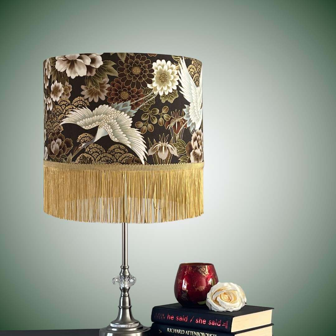 Japanese cranes and florals drum lampshade with gold fringe on table