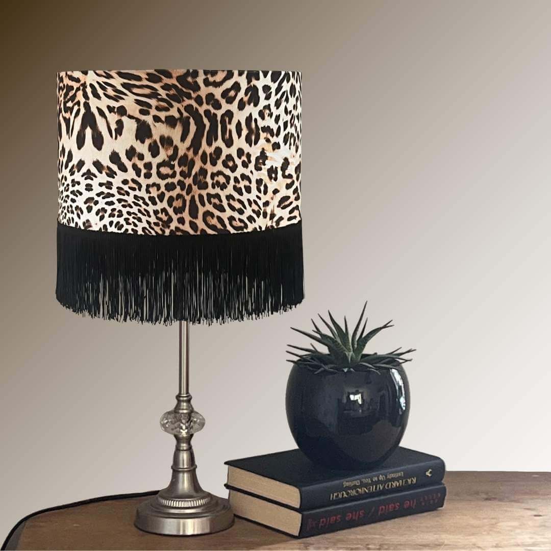 Leopard print velvet lampshade with black fringe on table