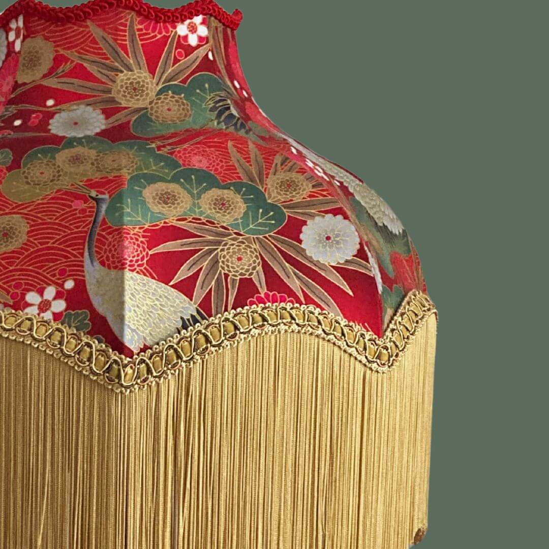Ornate vintage style lampshade with gold fringe and red japanese fabric with cranes, florals and gold metalic accents detail of fringe