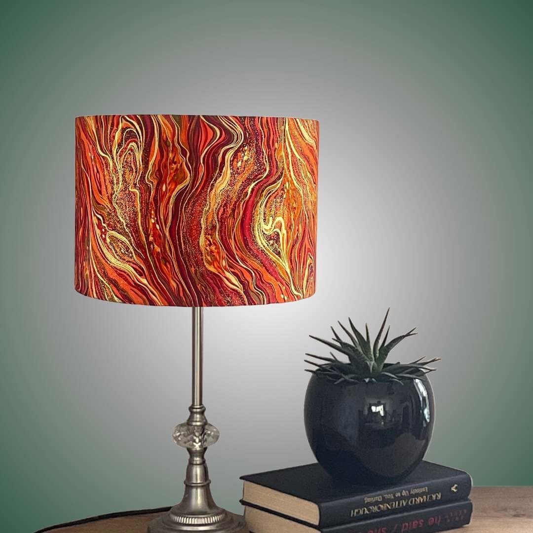 liquid marle effect drum lampshade orange red & gold swirls on a table setting