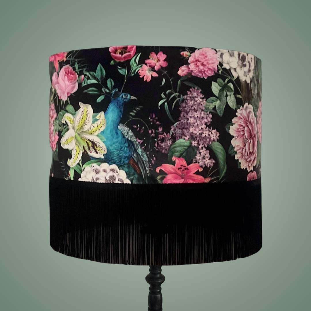 Velvet drum lampshade on a pendant in a Romantic design with peacocks and lush floral blossoms on a black background with fringe