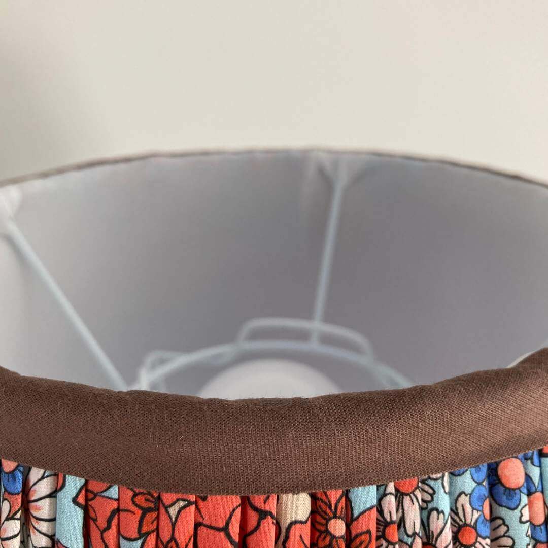 Pleated lampshade in liberty style fabric small florals in orange, blue & turquoise with chocolate brown trim top and bottom top detail