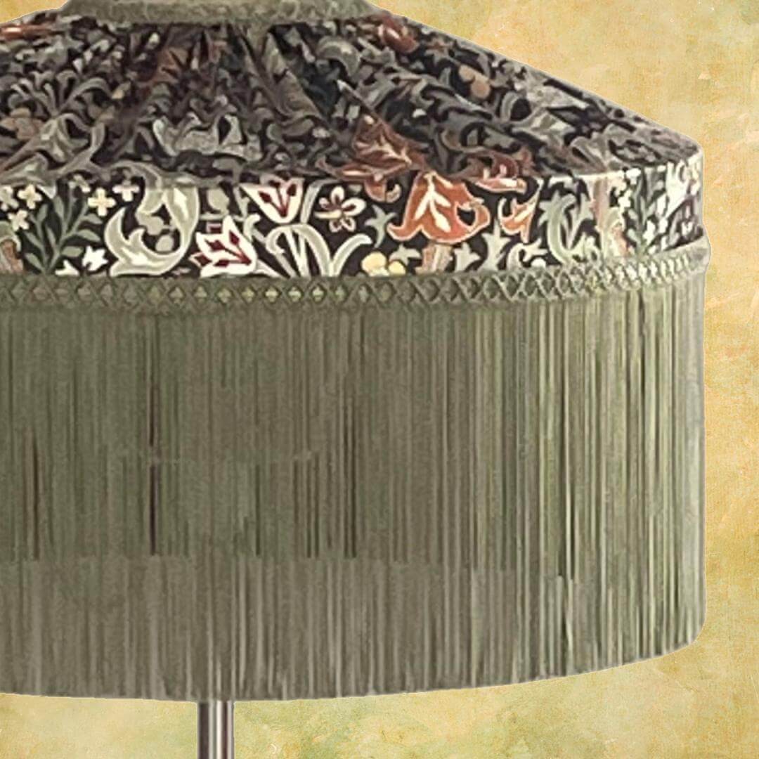 William Morris Golden Lily Satin Tiffany style lampshade with sage fringe on lamp base close up