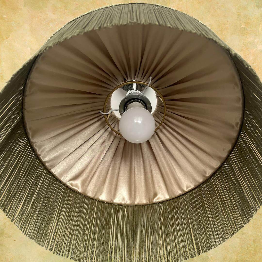 William Morris Golden Lily Satin Tiffany style lampshade with sage fringe on lamp base showing gold pleated lining