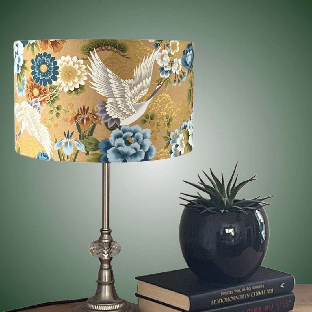 Japanese cranes drum lampshade with blue & white florals on table with plant