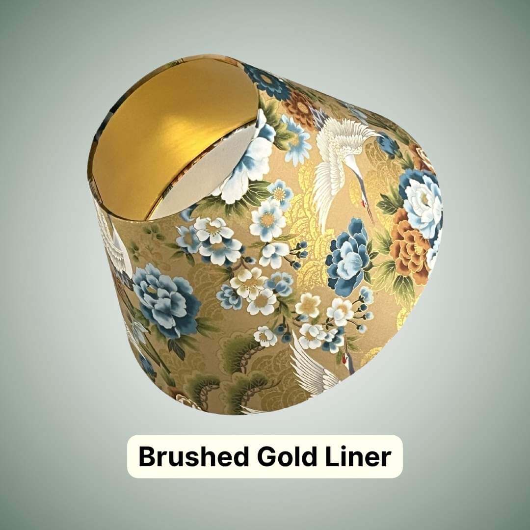 Conical lampshade in Japanese cranes fabric with blue and bronze florals on a gold background with a brushed gold lining