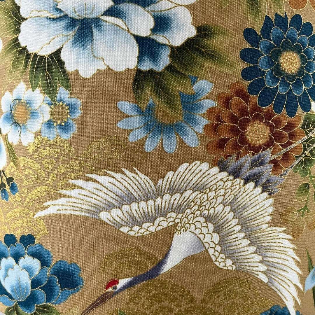 Japanese cranes fabric with blue, bronze & white florals on a soft gold background