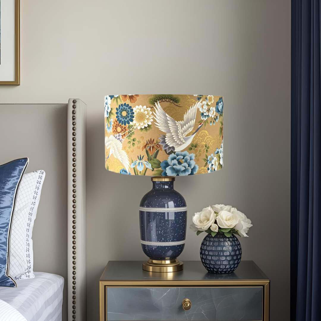 Japanese cranes drum lampshade with blue & white florals  on a bedside table