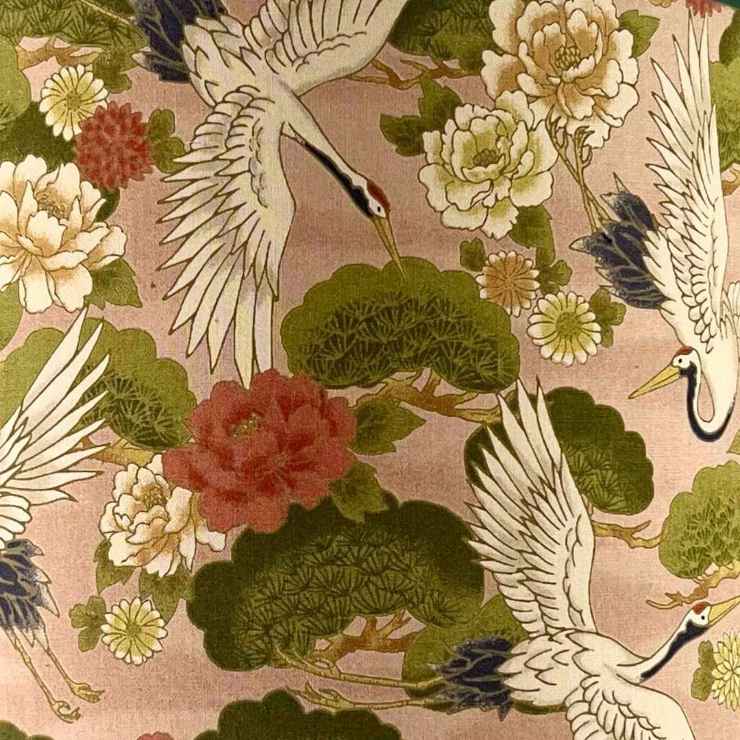 Traditional Japanese fabric design with cranes and flowers on a pink background