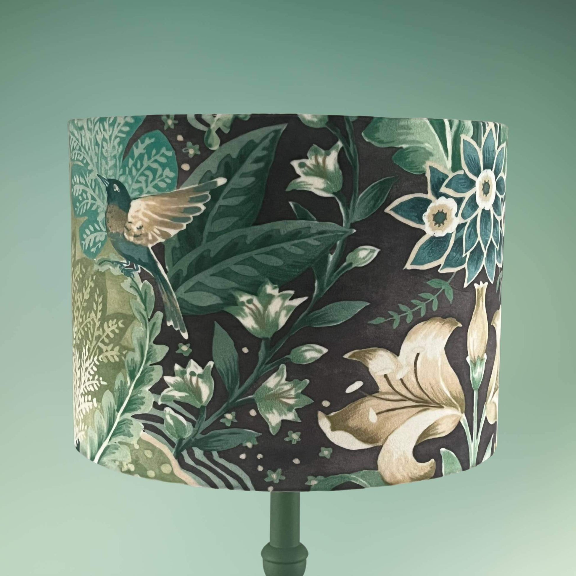 Drum lampshade with bold green floral pattern in a william morris style on green base