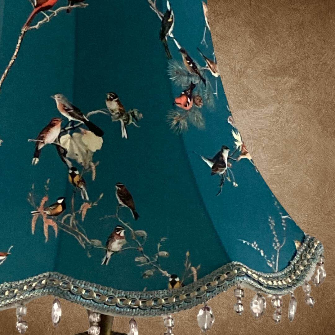 bowed empire vintage style lampshade with scalloped base, teal fabric and colourful garden birds, trimmed with a smoke grey beaded trim and braid with gold details, close up