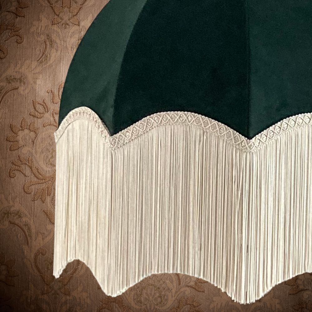 Dark green velvet vintage style dome or parachute lampshade with a deep ivory fringe close up