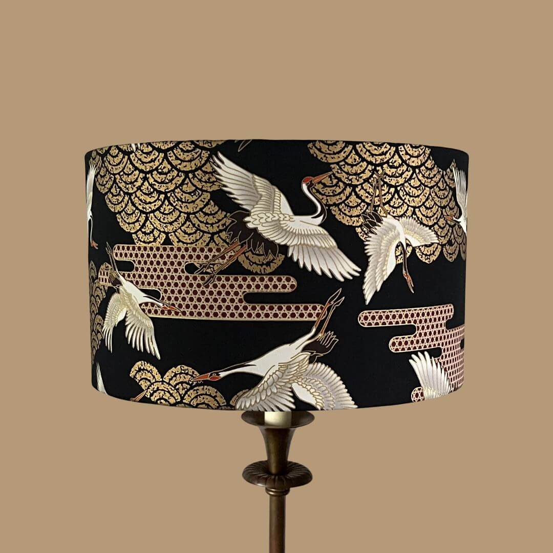 Art Deco style Japanese Cranes Lampshade that features cranes in flight and Art Deco-style clouds on a black background with gold metallic highlights 