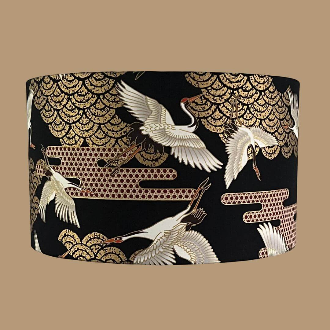 Art Deco style Japanese Cranes Lampshade that features cranes in flight and Art Deco-style clouds on a black background with gold metallic highlights