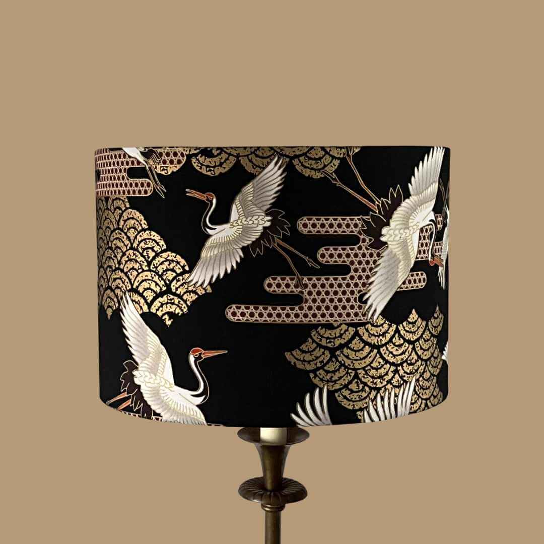 Art Deco style Japanese Cranes Lampshade that features cranes in flight and Art Deco-style clouds on a black background with gold metallic highlights 