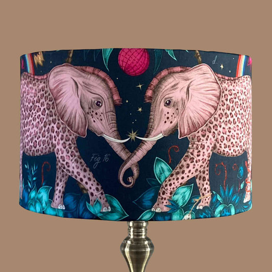 Emma J Shipley zambezi Drum Lampshade with pink leopard spotted elephants and jungle foliage on a navy blue background 