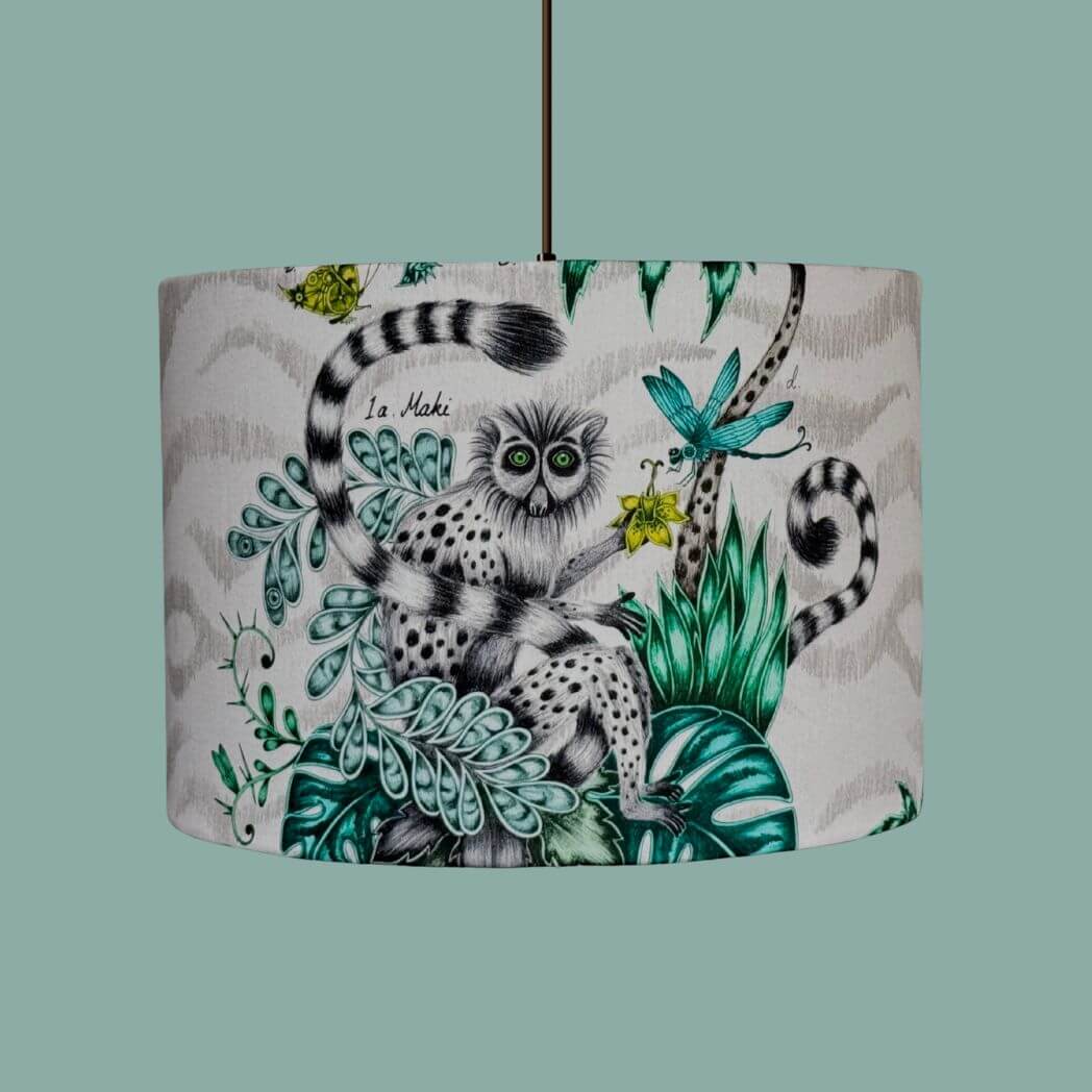 Drum lampshade made from the Emma Shipley fabric Lemur in the jungle colourway, featuring a quirky lemur with butterflies, dragonflies, florals, jungle palms and foliage. 