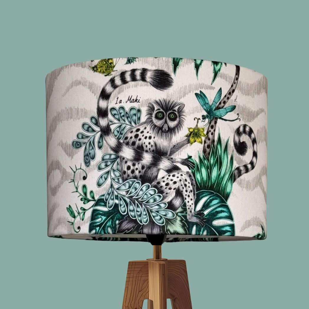 Drum lampshade made from the Emma Shipley fabric Lemur in the jungle colourway, featuring a quirky lemur with butterflies, dragonflies, florals, jungle palms and foliage. 