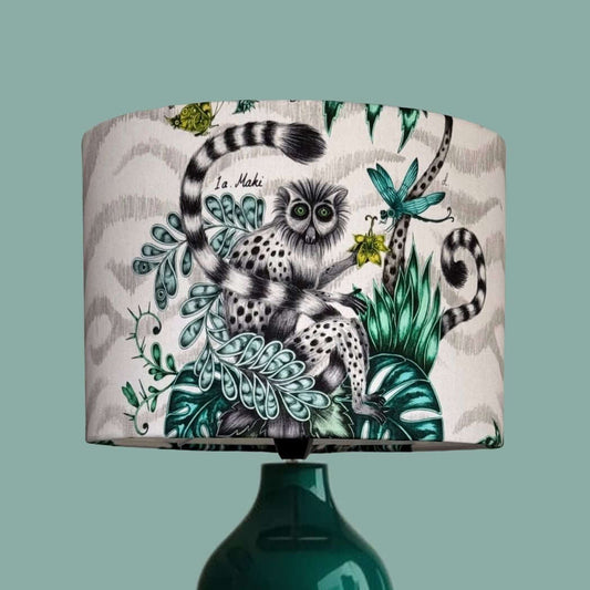Drum lampshade made from the Emma Shipley fabric Lemur in the jungle colourway, featuring a quirky lemur with butterflies, dragonflies, florals, jungle palms and foliage. 