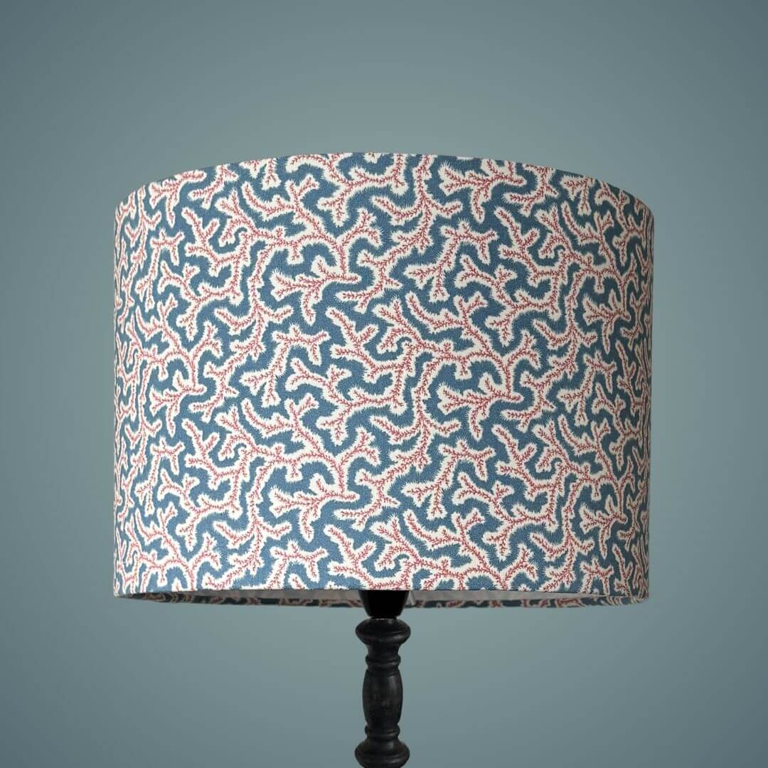 Drum lampshade made with Ian Sanderson Jubilee fabric, a small print design based on a seaweed pattern shown on a tall black lamp stand