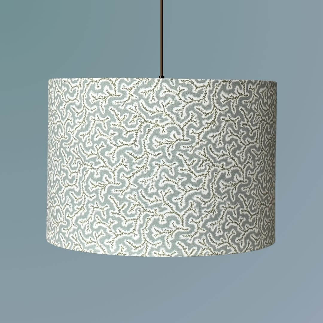 Drum lampshade made from Ian Sanderson Dulcie fabric in Thyme -pale blue and green featuring an abstract coral-like pattern, shown on a ceiling pendant
