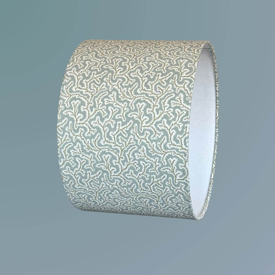 Drum lampshade made from Ian Sanderson Dulcie fabric in Thyme -pale blue and green featuring an abstract coral-like pattern.