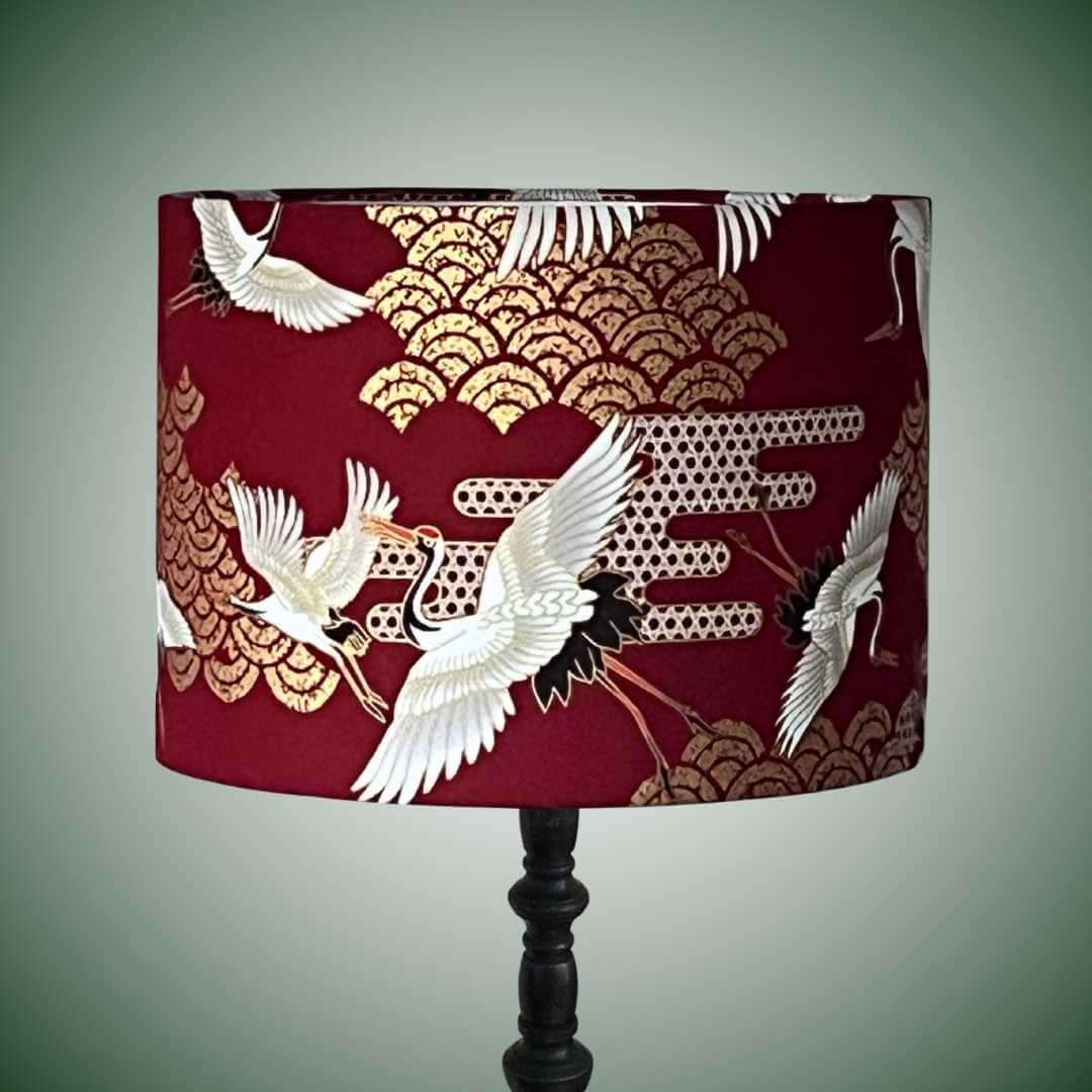 Red drum lampshade with japanese cranes and art deco style clouds on a black lampbase
