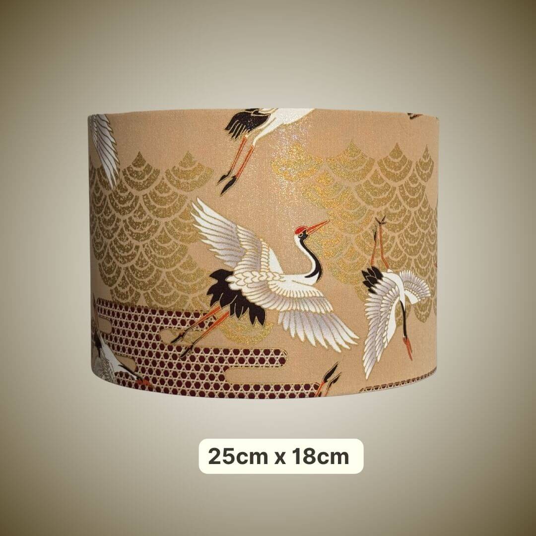 A cylindrical drum lampshade featuring a traditional Japanese-style print of cranes and gold wave patterns on a beige background, shown against a neutral gradient background with a size label of 25cm x 18cm.