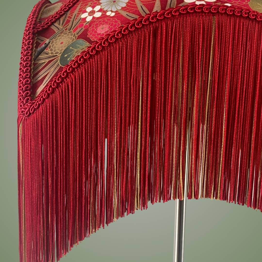 bowed empire lampshade with cut outs in red japanese fabric and fringe showing details