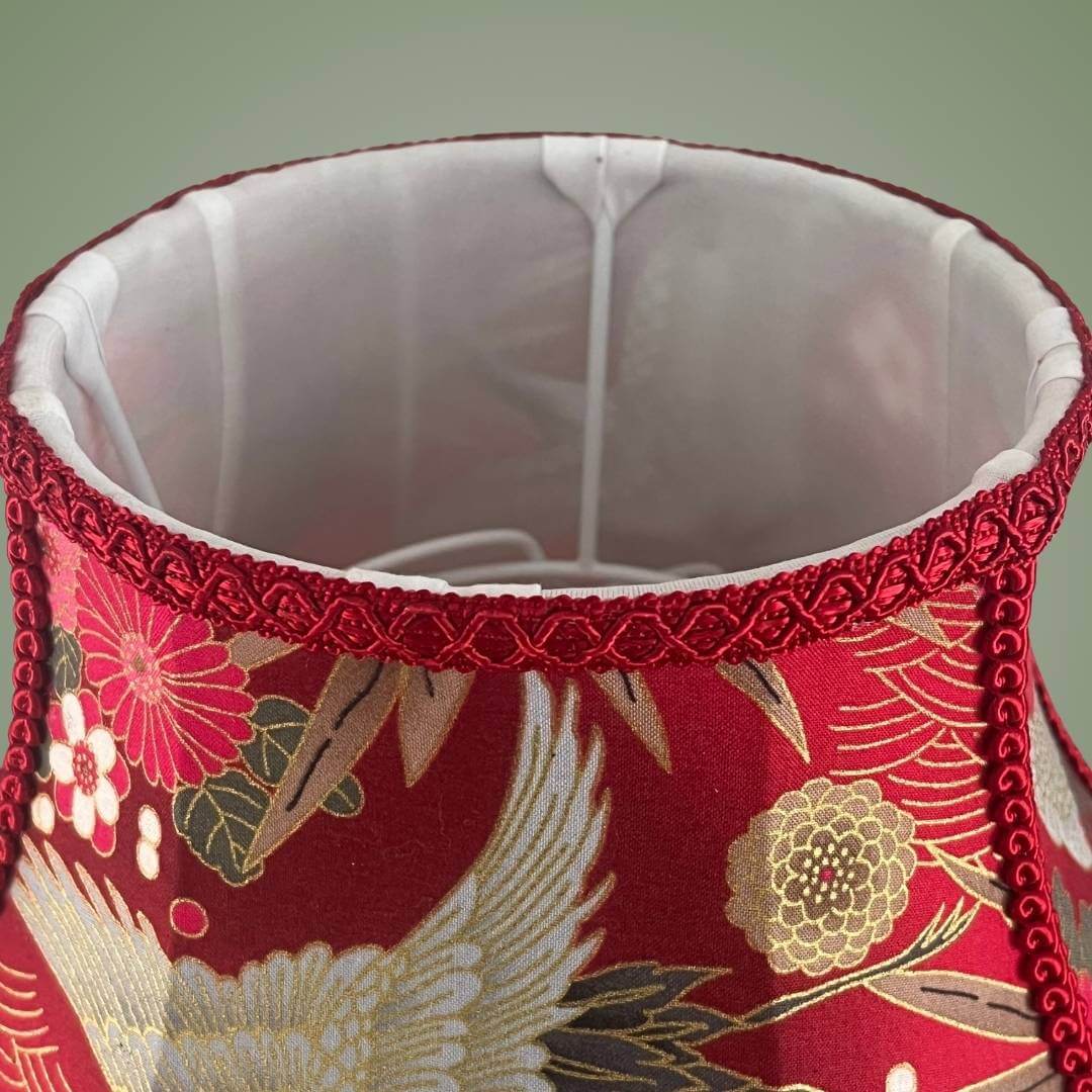 bowed empire lampshade with cut outs in red japanese fabric and fringe showing  top