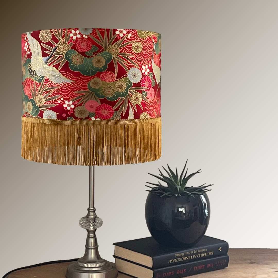 Drum Lampshade made with Authetic Japanese fabric with cranes, florals, metalic gold accents and gold fringe on console