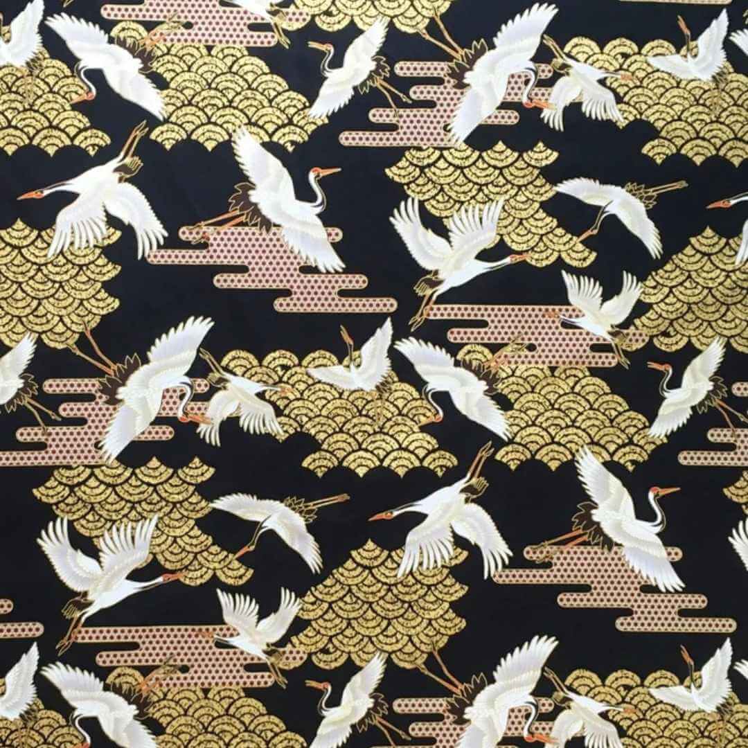 Fabric with Japanese cranes and Art Deco-style clouds on a black background with gold metallic highlights