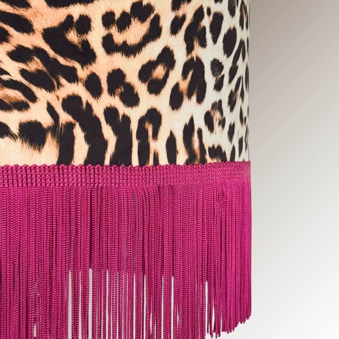 Close up detail of leopard print velvet drum lampshade with a hot pink fringe.