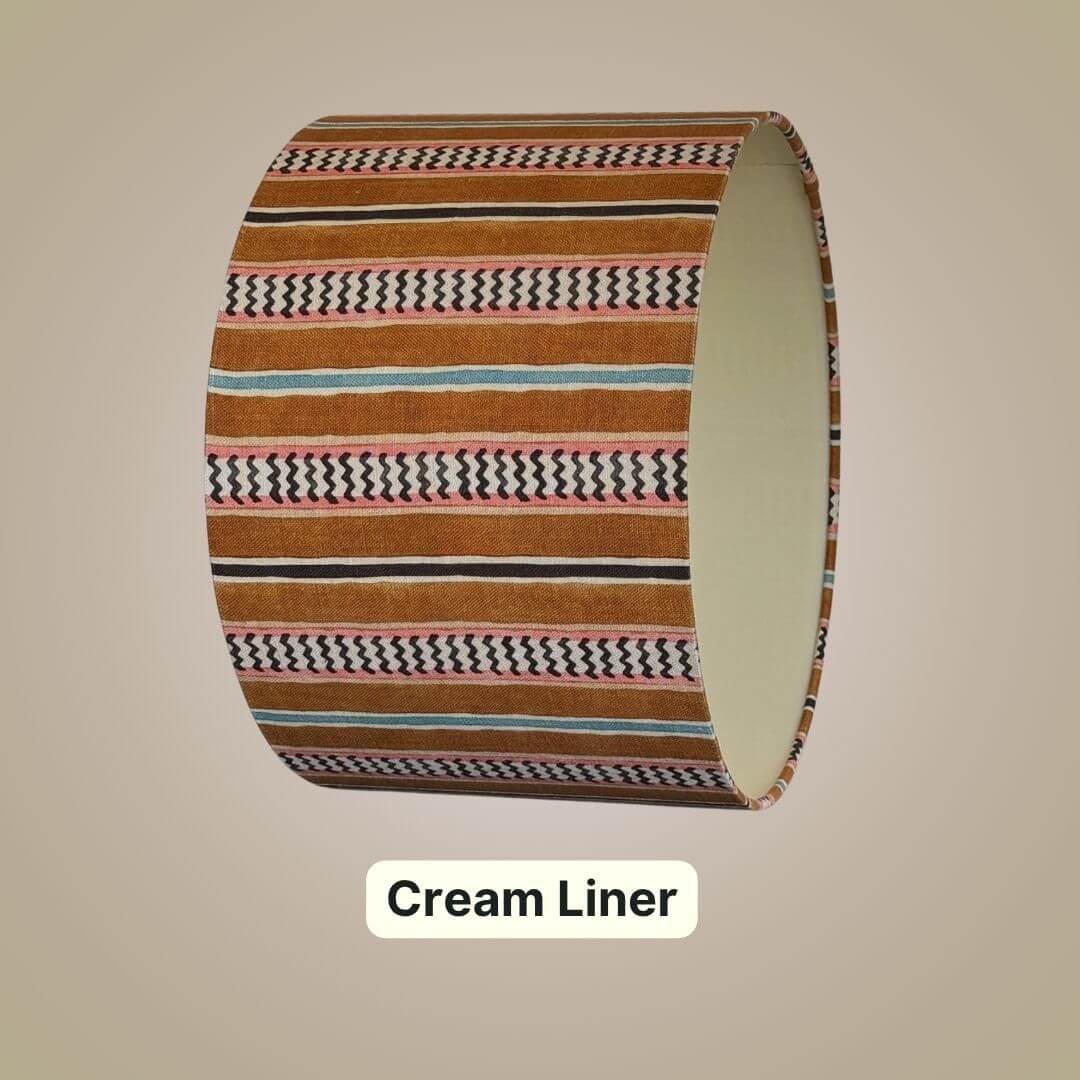 drum lampshade in Linwood hire wire fabric. Featuring an alternating chevron and solid stripe pattern, shown with a cream lining 