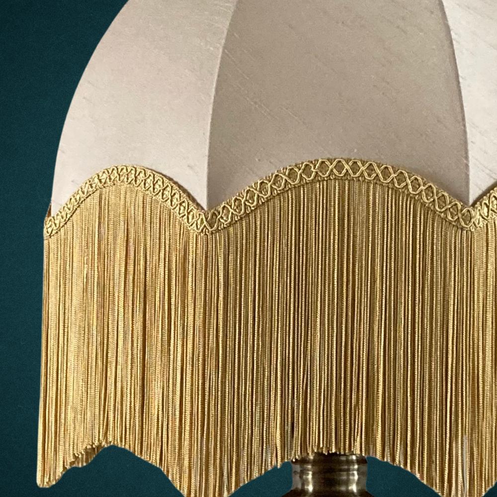 vintage style dome parachute lampshade with neutral champagne silk and deep gold fringing tassels close up