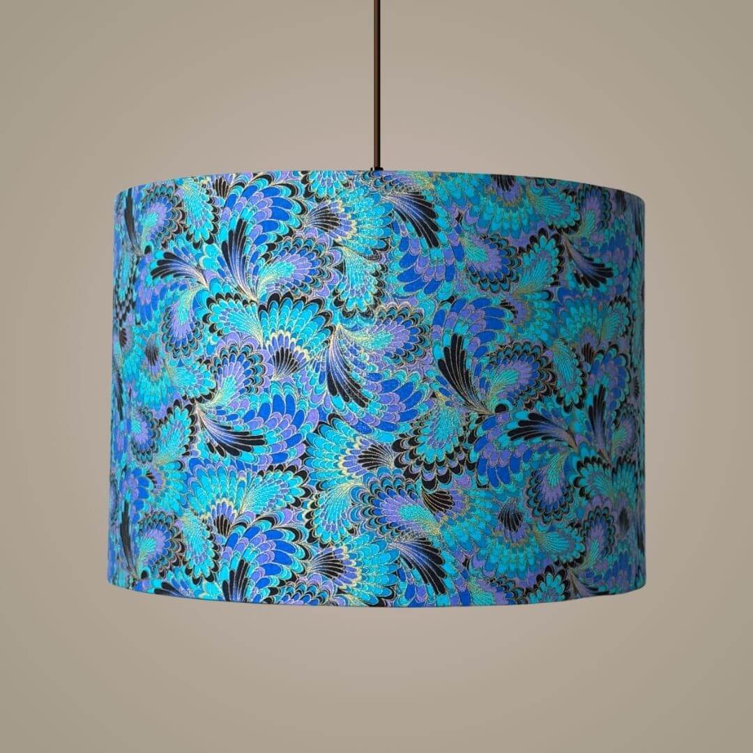 Palazzo Peacock-feather design drum lampshade shown on a ceiling pendant