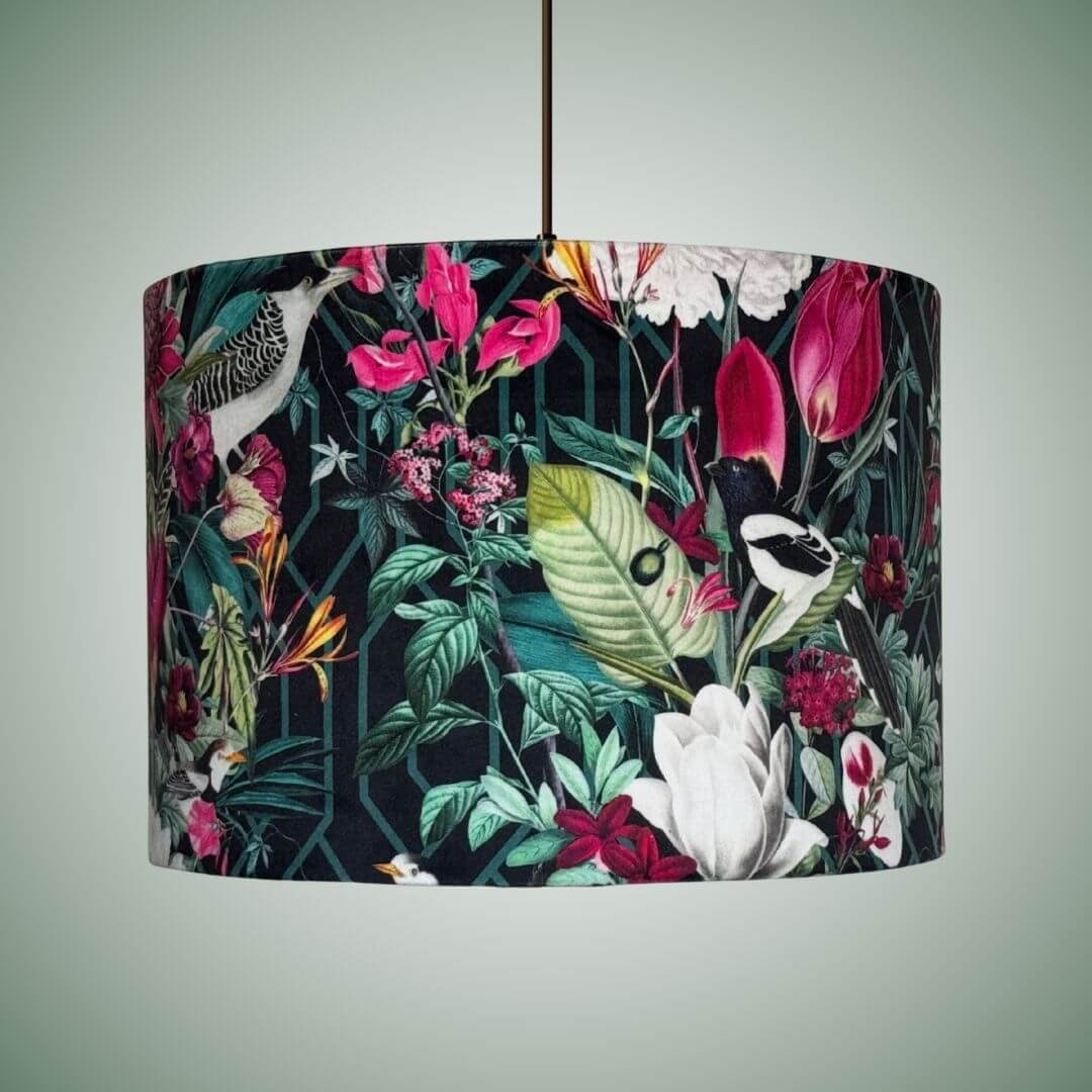 A  velvet drum pendant lampshade featuring a tropical floral and bird pattern on a ceiling light