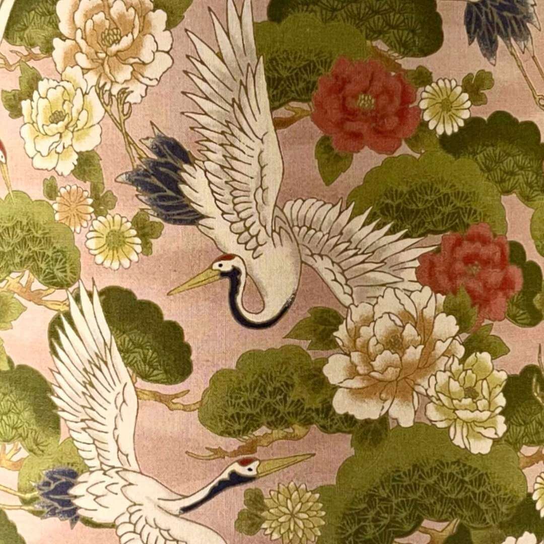 Traditional Japanese fabric design with cranes and flowers on a pink background