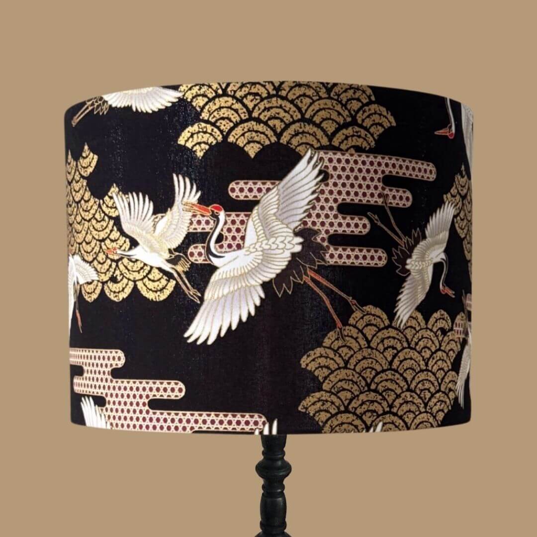 Japanese Cranes Lampshade, with cranes in flight and Art Deco-style clouds on a black background with gold metallic accents 
