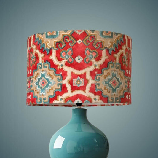 Linwood omega velvet kami drum lampshade in chilli shown on a blue ceramic lamp base